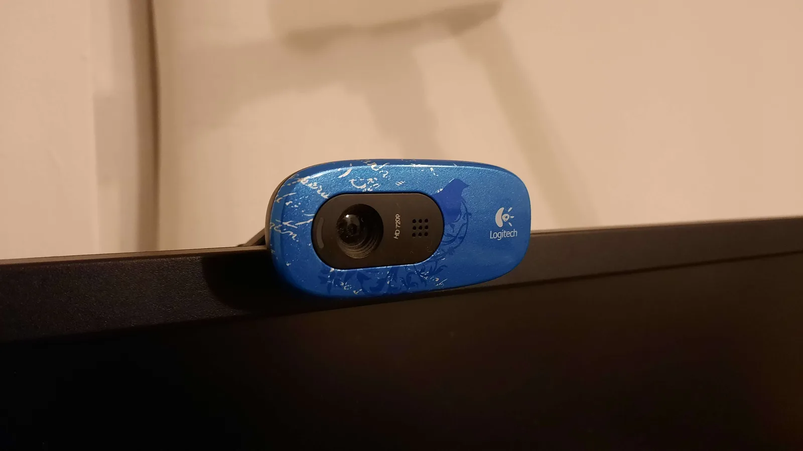 An external webcam clipped to the top edge of a computer monitor